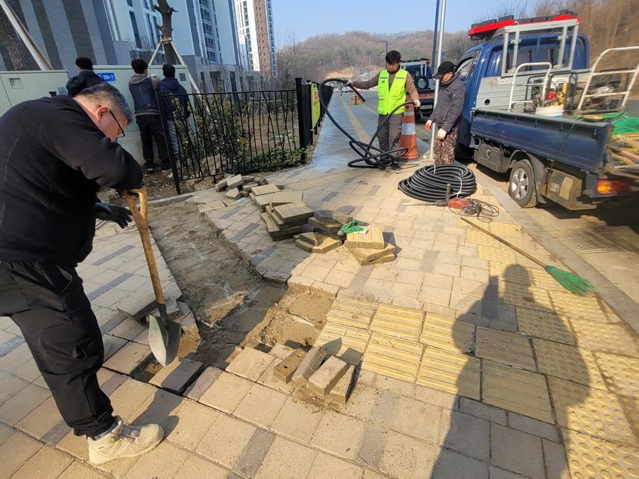 여러 색상의 블록을 배열해 색상 경계선을 맞춰 시공하는 작업 장면